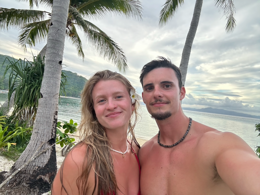 Selfie du couple sur une plage bordée de cocotiers
